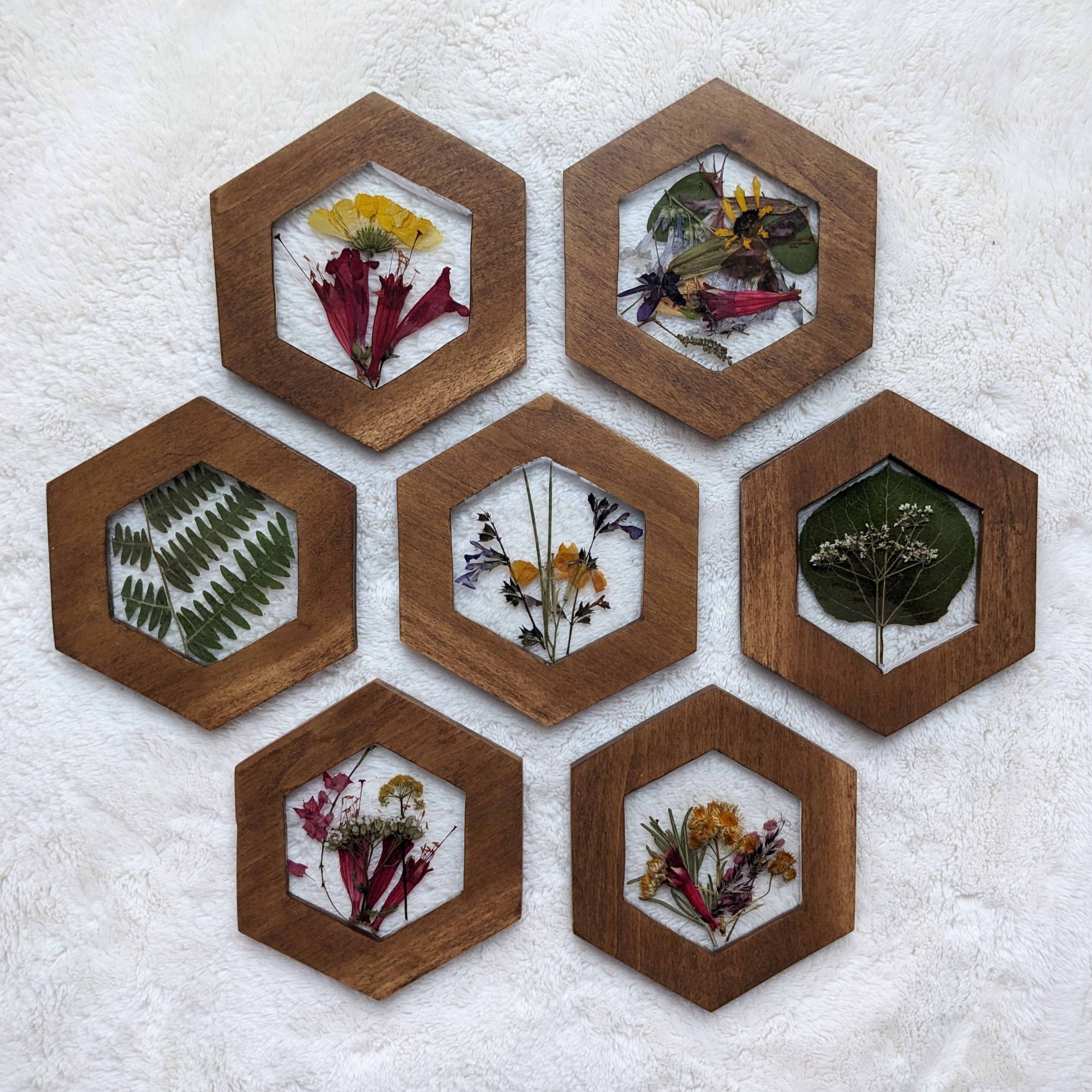 Hexagonal coasters with cutouts in the center, filled with resin and pressed flowers