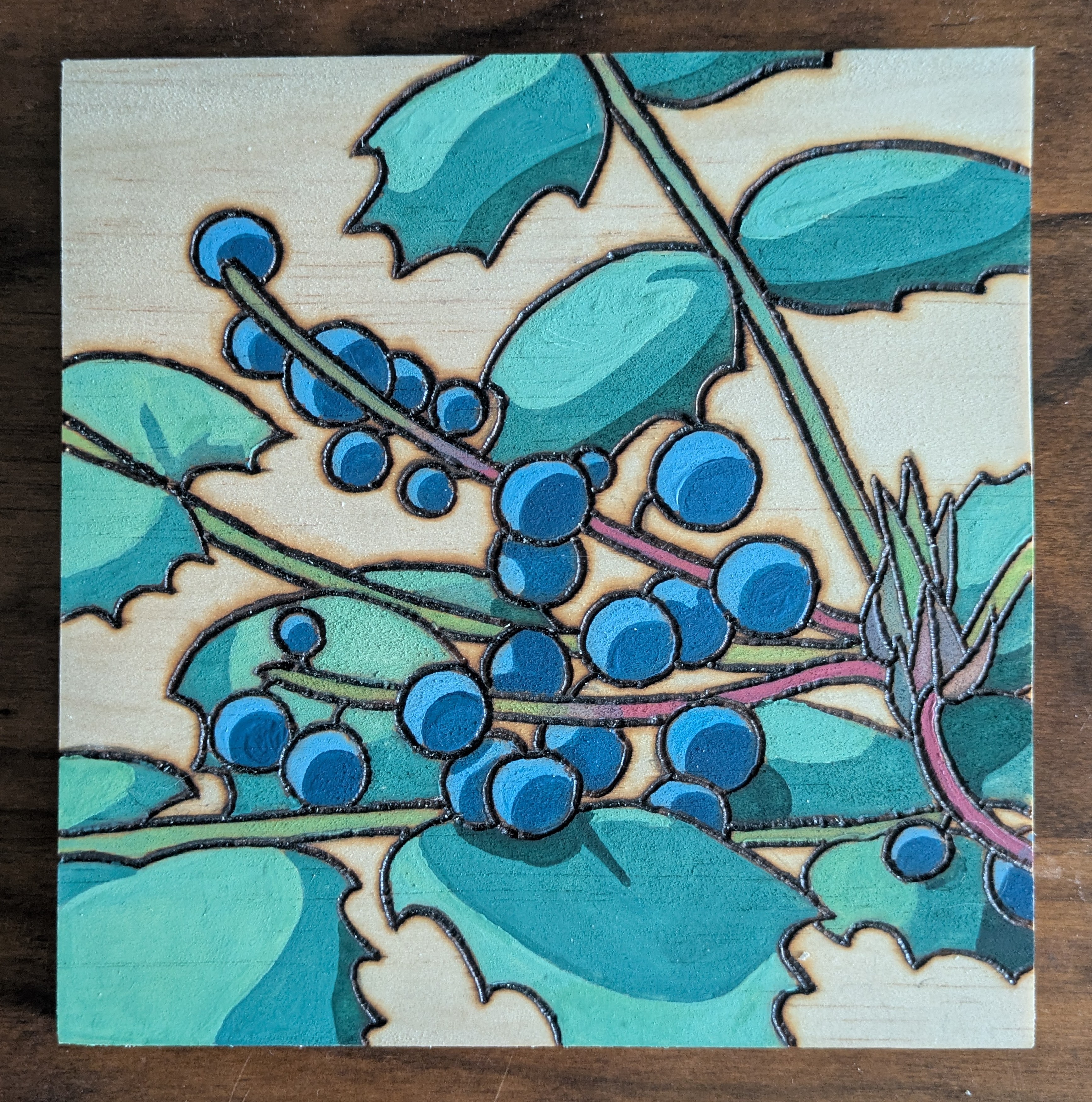 Pyrography and watercolor of Red, organge, and yellow berries on a branch