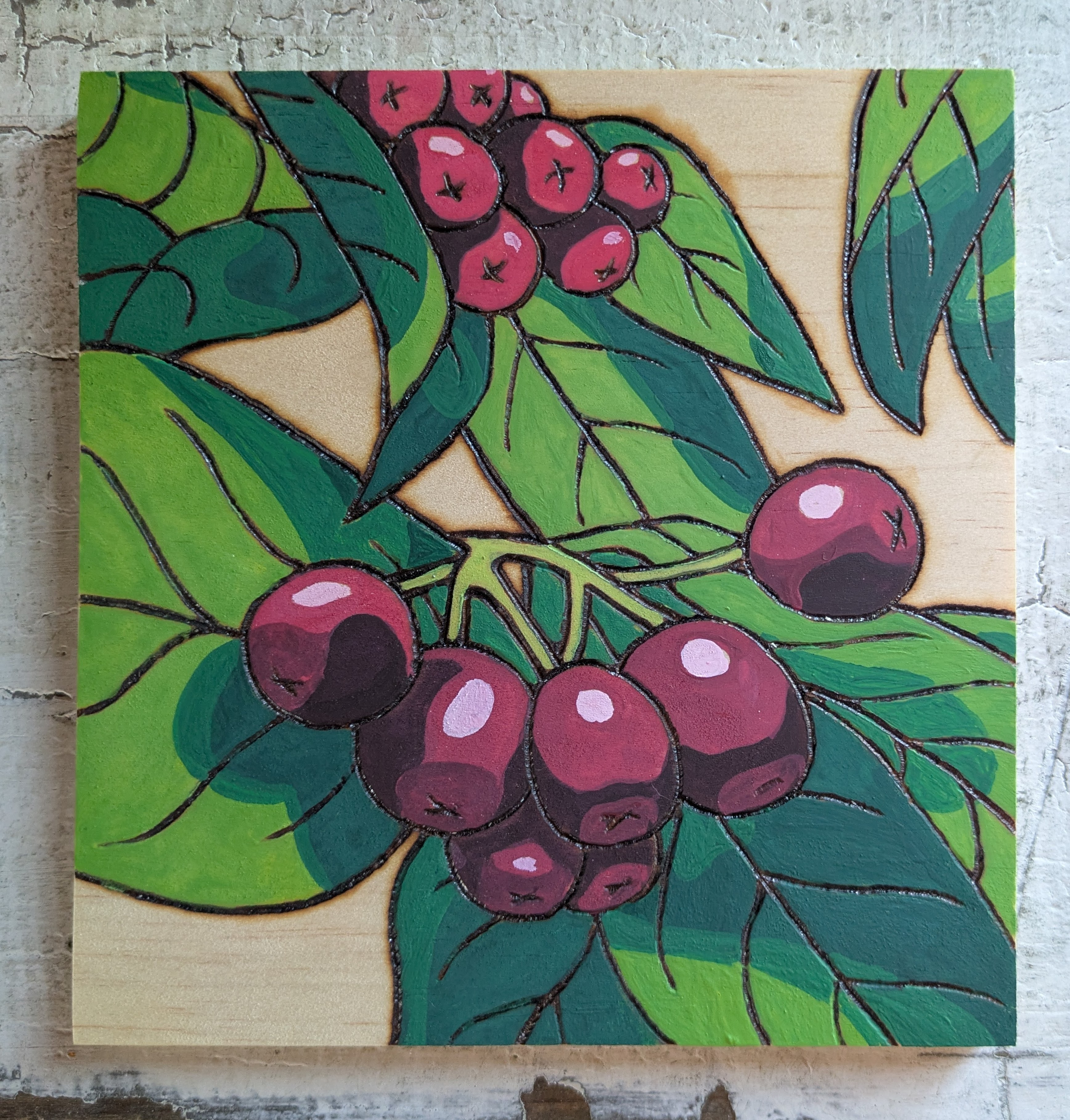 Pyrography and watercolor of bright red berries and stylized blue through red leaves