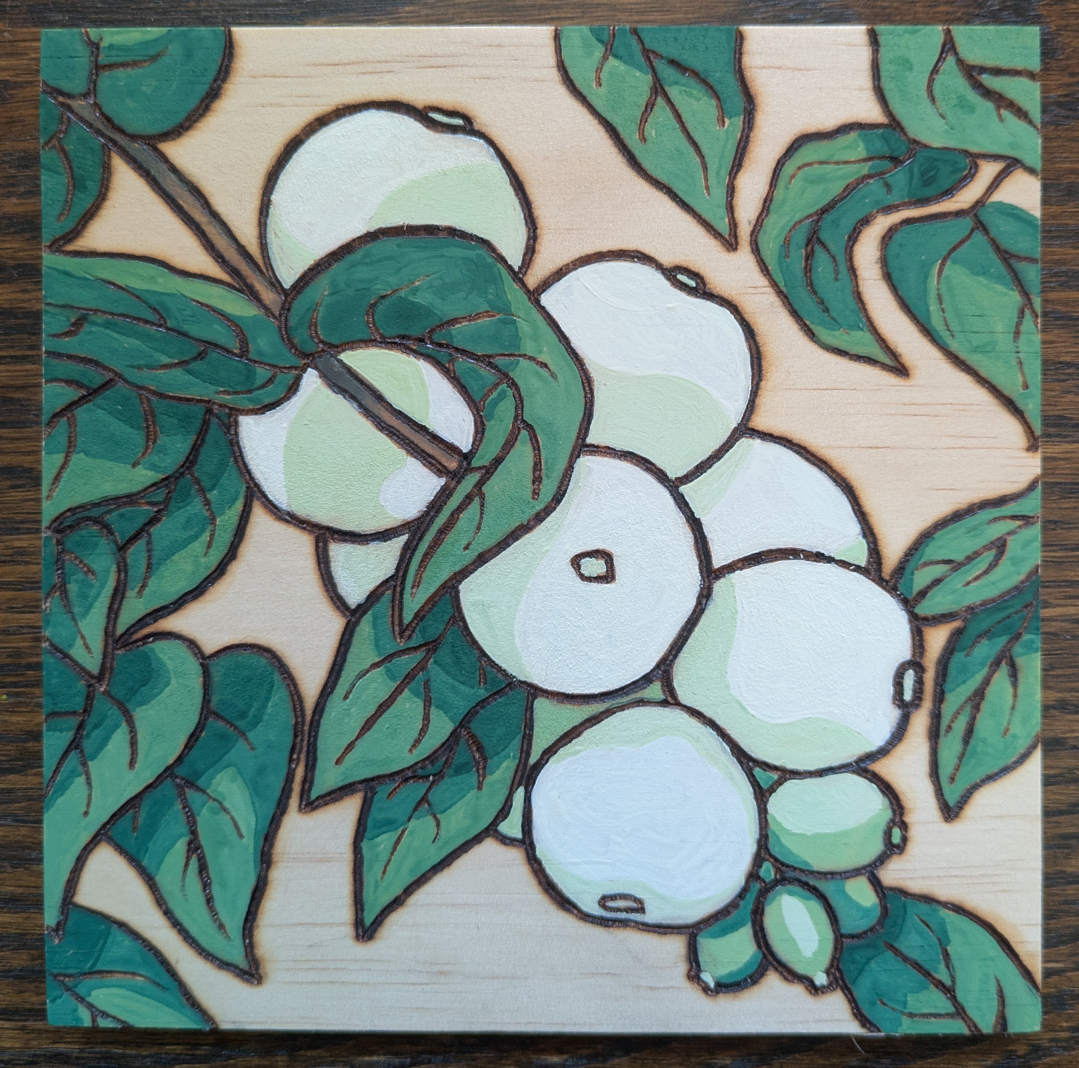 Pyrography and watercolor of Red, organge, and yellow berries on a branch