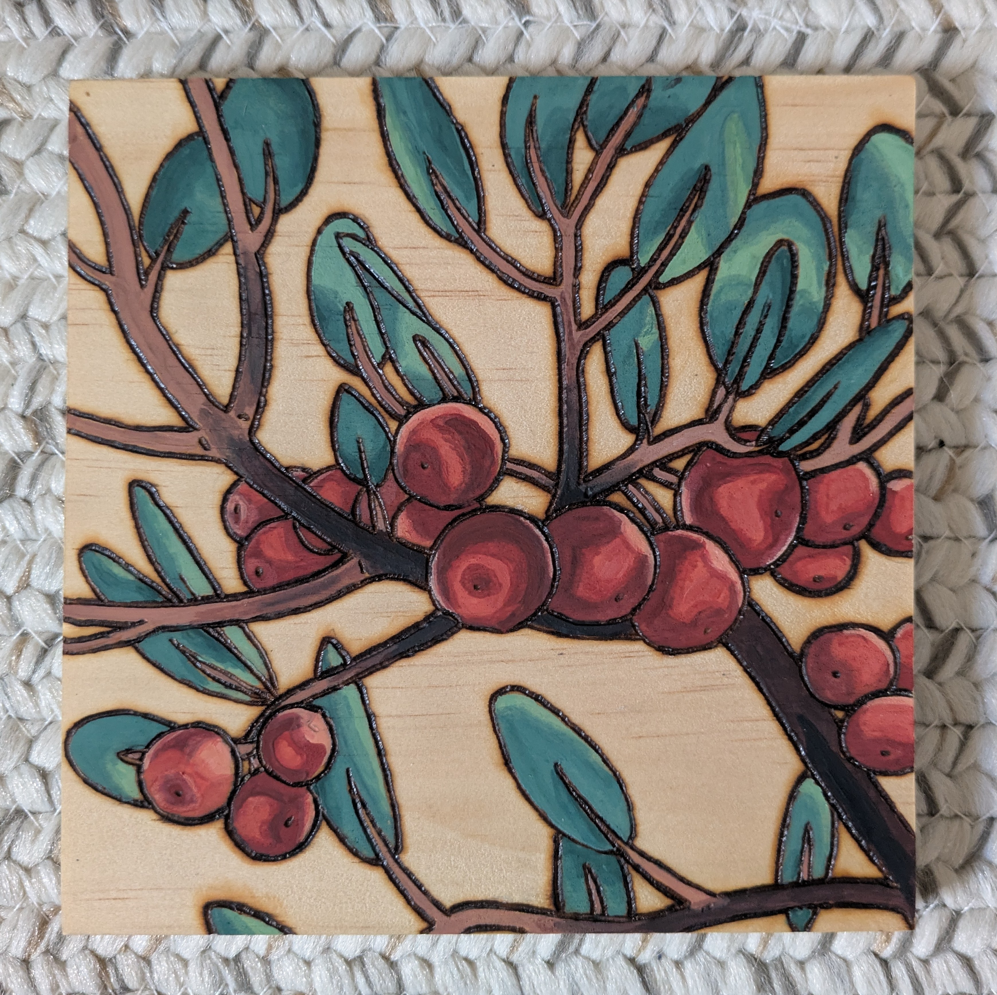 Pyrography and watercolor of Red, organge, and yellow berries on a branch