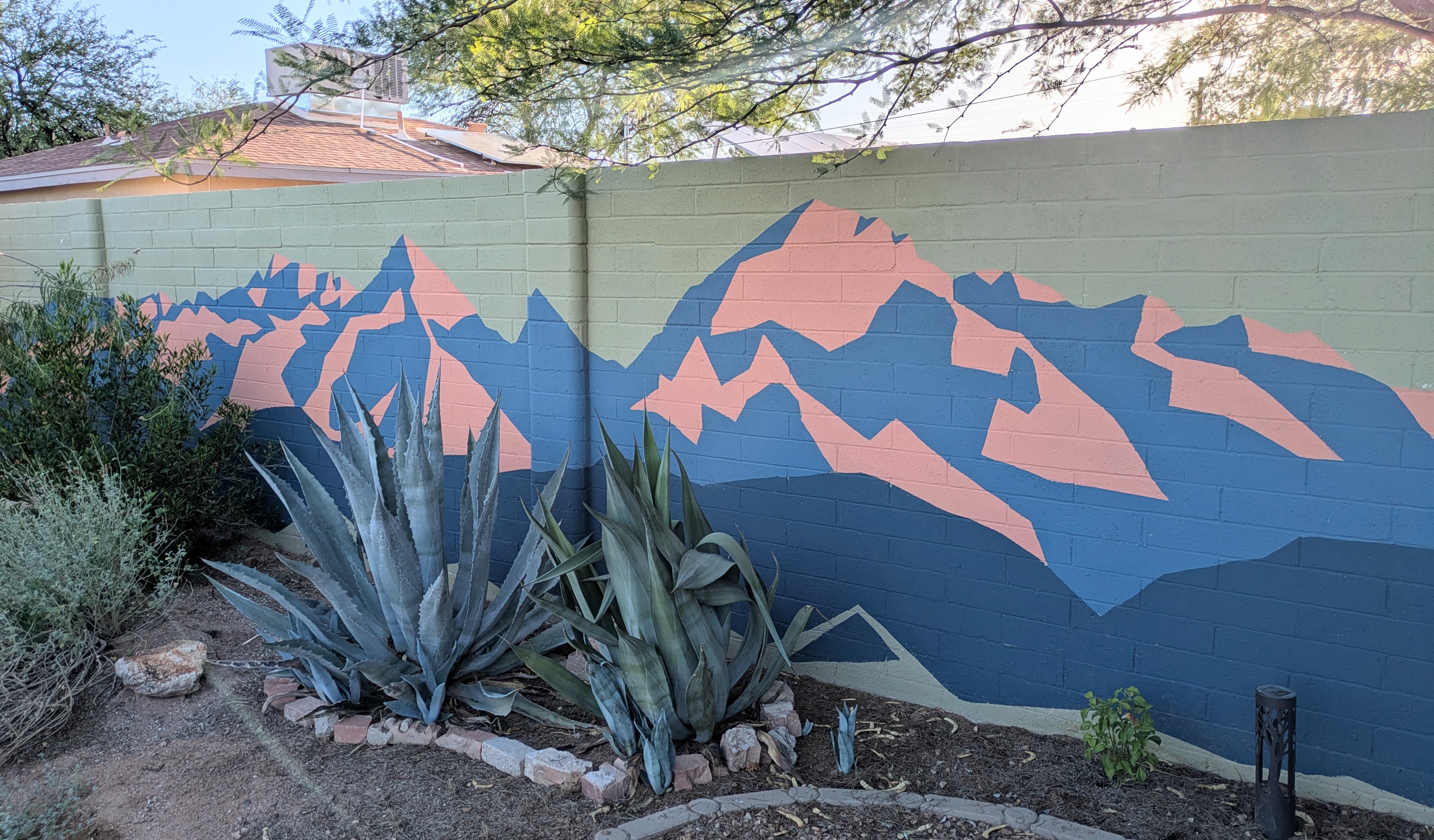 A green and white mural showing California poppies in the negative