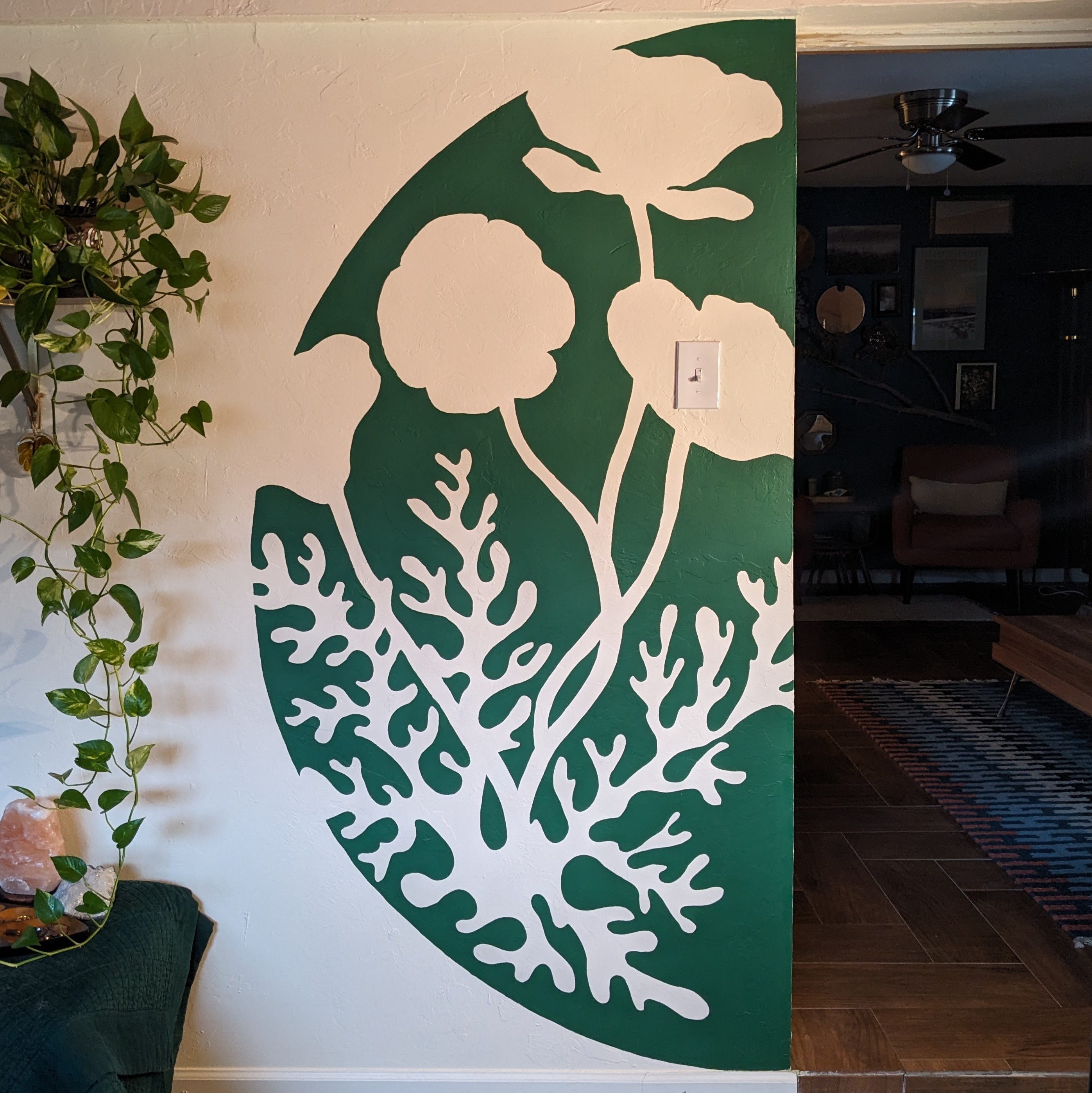 A green and white mural showing California poppies in the negative